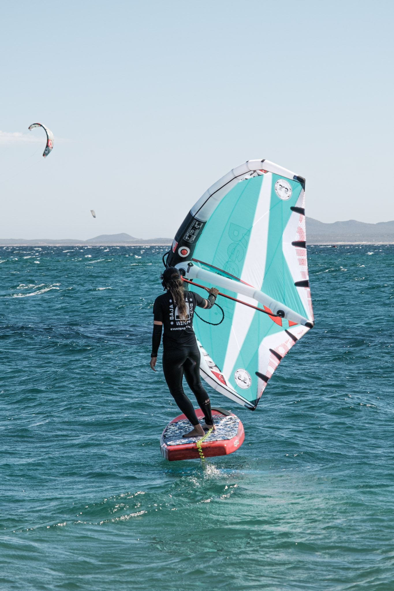 Wing foiler using a turquoise wing on the water