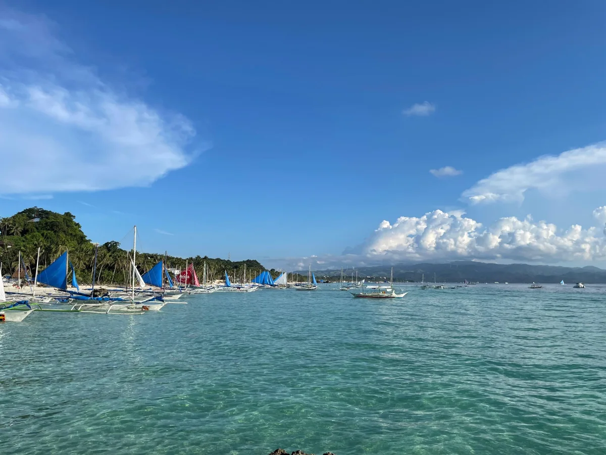 Sailboats near the Boracay shoreline on clear turquoise water