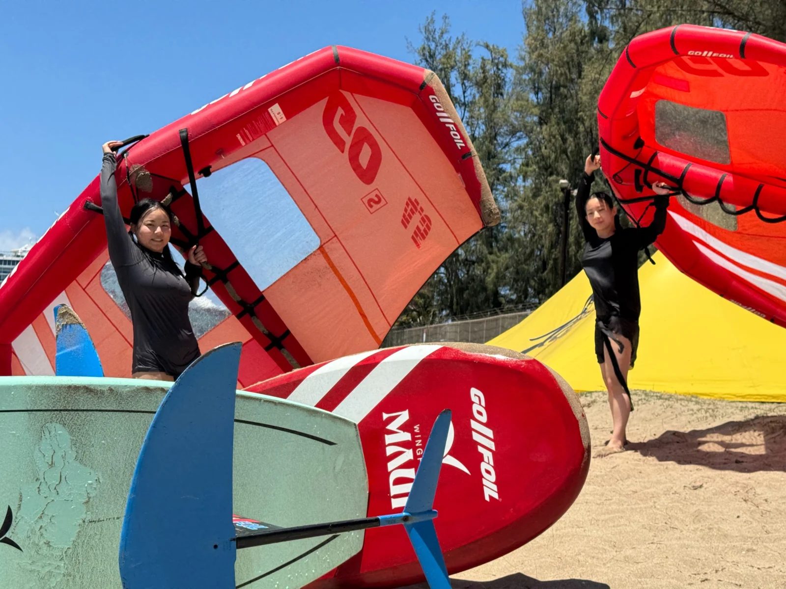 Riders preparing their wings and boards on shore