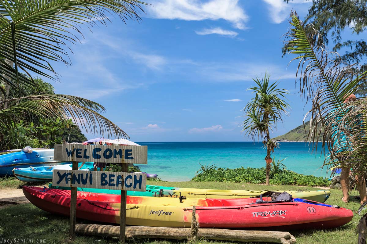 Colorful kayaks and a Ya Nui Beach sign overlooking the bay
